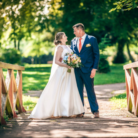 Jarní svatba v parku – novomanželé na dřevěném mostku, Radim a Adriana